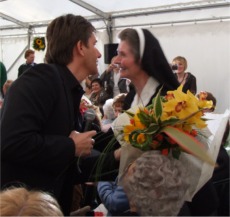 Daniel O'Donnell presents Sr Finian with a bouquet of flowers.